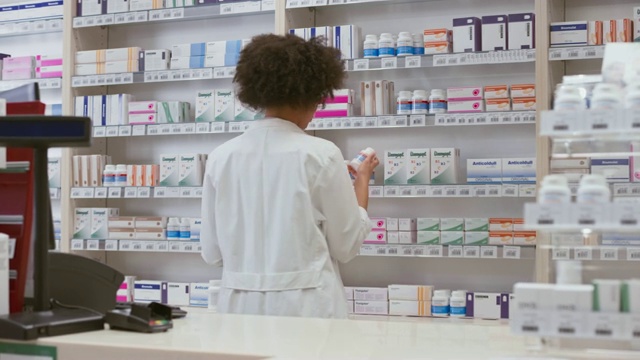一位微笑的女药剂师站在药店柜台后面的肖像视频下载