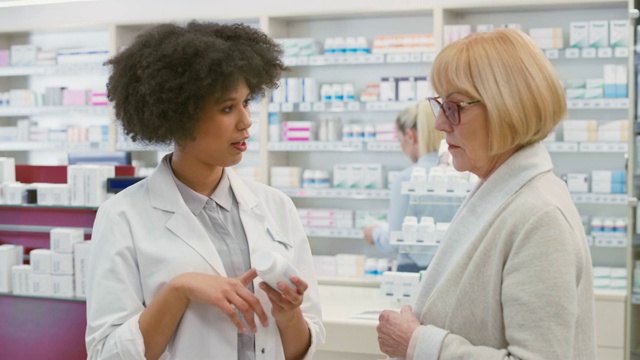 药店的女售货员向一位老年妇女推荐一种矿物质补充剂视频下载