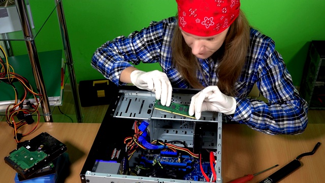 专业女性电脑修理工，将ram内存安装到桌面电脑主板上。静态的镜头。4 k UHD视频素材