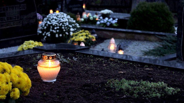 红烛焰后的玻璃，在黑色的地面坟墓墓地。4 k视频下载