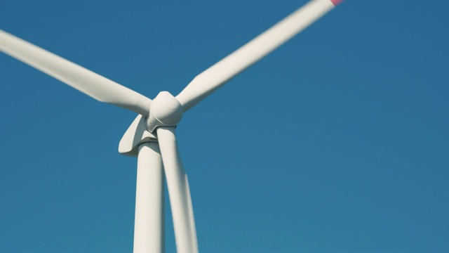替代能源。大型旋转风力涡轮机叶片对蓝天风力农场特写。光滑的运动。4 k的片段视频素材