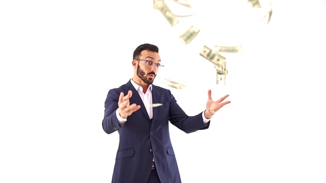 戴眼镜的男子向白色背景上扔钞票。慢动作视频素材