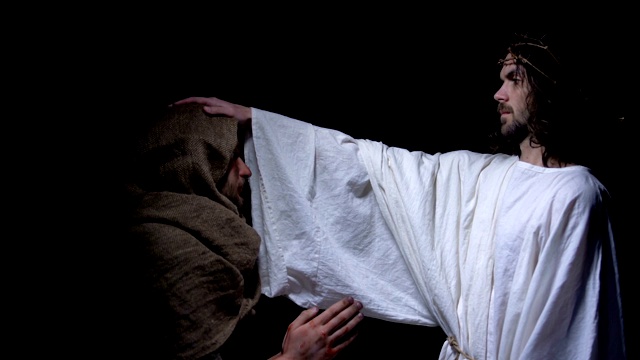 耶稣基督戴着荆棘冠冕祝福穿着长袍的穷人，爱和仁慈视频下载
