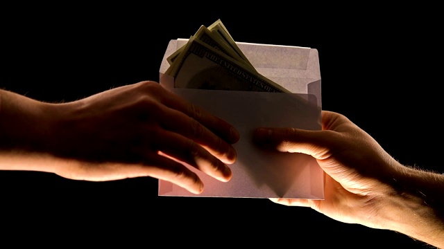 手给信封里的钱孤立黑钱，贪污或非法工资视频素材