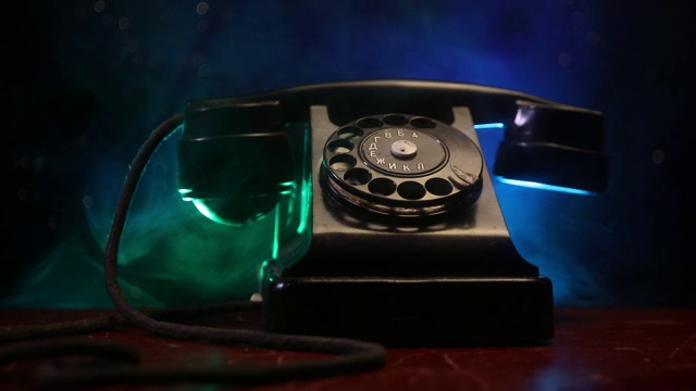 旧的黑色电话上的旧木板与艺术黑色背景与雾和色调的光。空的空间。有选择性的重点视频素材