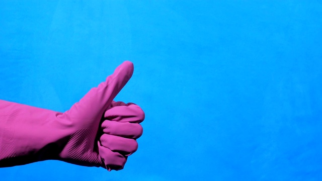 蓝色底色的紫色橡胶手套上的清洁手。喜欢和不喜欢的手势。视频下载