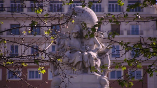 在西班牙马德里，通过分支，以慢镜头展示在塞万提斯纪念碑顶部的球形雕像视频素材