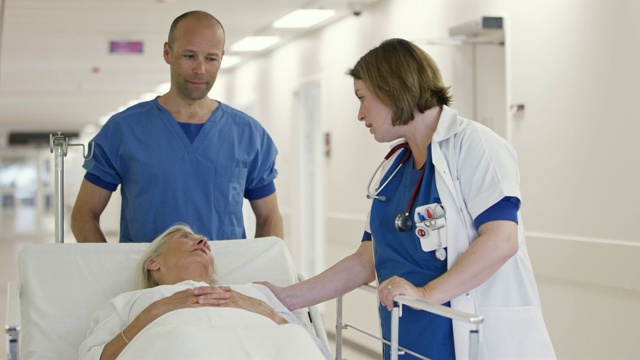 医生在医院的轮床上安慰老病人视频素材