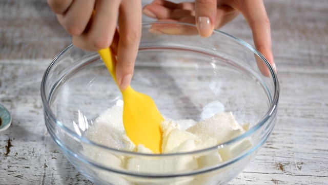 女人的手搅拌奶油准备蛋糕。视频素材