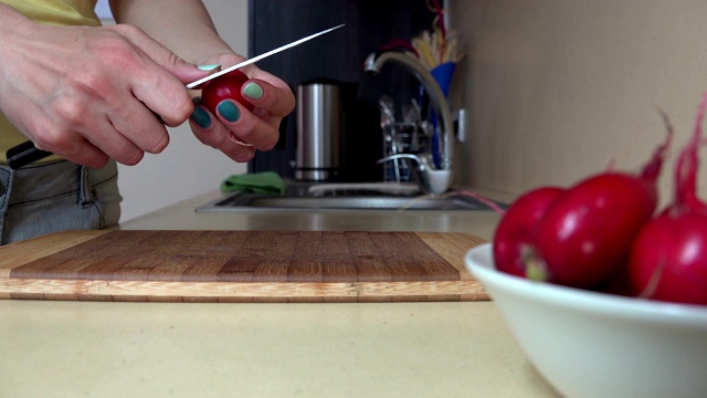 女用手在切菜板上切萝卜做沙拉。4 k视频素材
