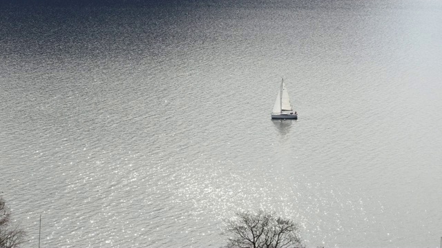 远处的帆船漂在平静的水面上视频素材