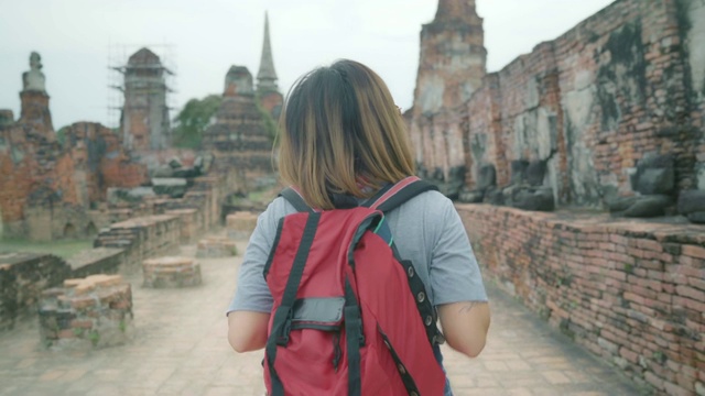 旅行者亚洲女人在泰国大城府度假旅行，背包女享受她的旅程在传统城市惊人的地标。生活方式女性旅游度假概念。视频素材