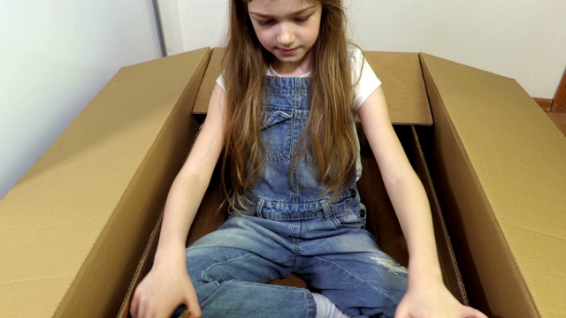 可爱的小女孩在玩纸板箱视频素材
