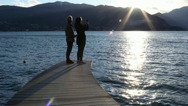 一对夫妇走到湖边码头上，向外眺望视频素材