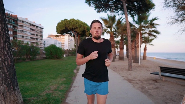 一个在海滩上奔跑的自信男人。视频素材