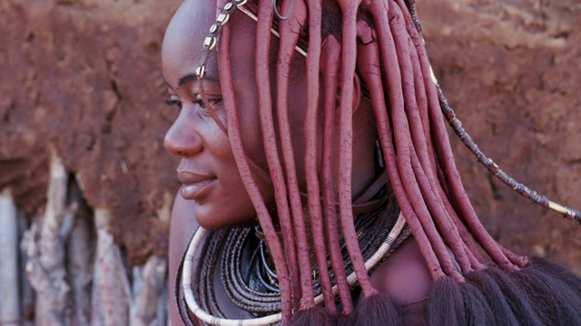 纳米比亚，一个漂亮的辛巴女孩展示头饰和颈部珠宝的4K特写俯视图视频下载