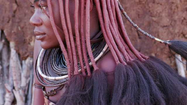 纳米比亚，一个漂亮的辛巴女孩的4K特写俯仰镜头，展示着头饰和脖子上的珠宝视频下载