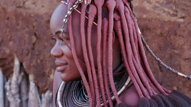 纳米比亚，一个漂亮的辛巴女孩的4K近距离侧视图，展示头饰和颈部珠宝视频下载