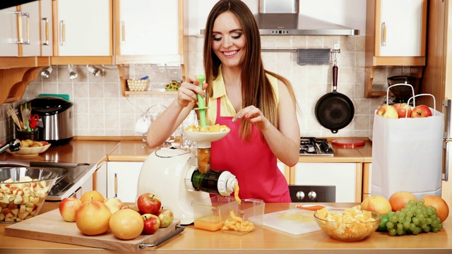 女人在4K榨汁机里榨橙汁视频素材
