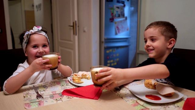 欢快的孩子们在吃早餐时祝酒以示庆祝视频素材