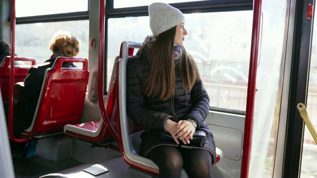这位年轻的女士乘公共交通工具。公车上的女人。用摄像机记录下女孩的动作。4视频下载