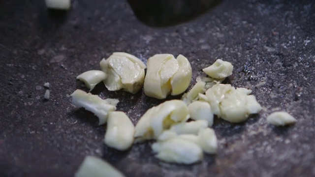 在印度尼西亚马鲁古的班达岛，将大蒜压碎在石盘上视频下载