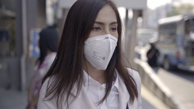 亚洲女性要去工作。她戴着N95口罩。防止PM2.5粉尘和雾霾。她是咳嗽视频素材