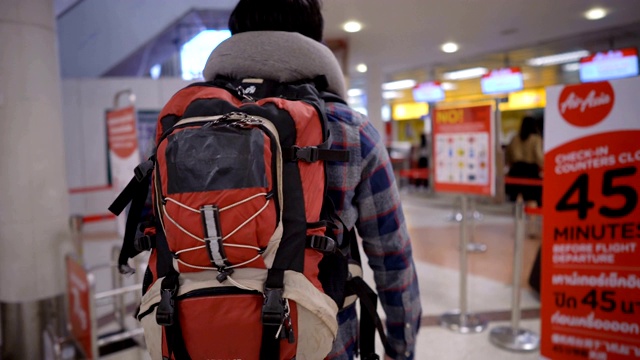 背包客拿着智能手机走向机场值机柜台视频下载