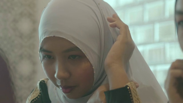 穿着民族服装的穆斯林妇女正在调整她的头巾视频素材