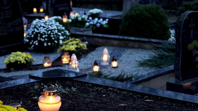 在万圣节期间墓地里燃烧的蜡烛。4 k视频下载