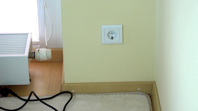 人工从墙壁插座上取下安全插头并插入插头线视频素材