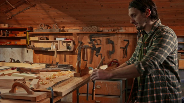 一名男木匠，在他的店里用刨子刨成方形视频素材