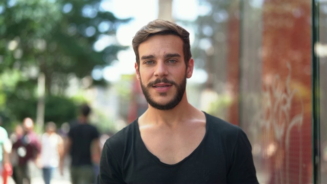 英俊的男人与黑衬衫和胡子肖像在城市视频素材