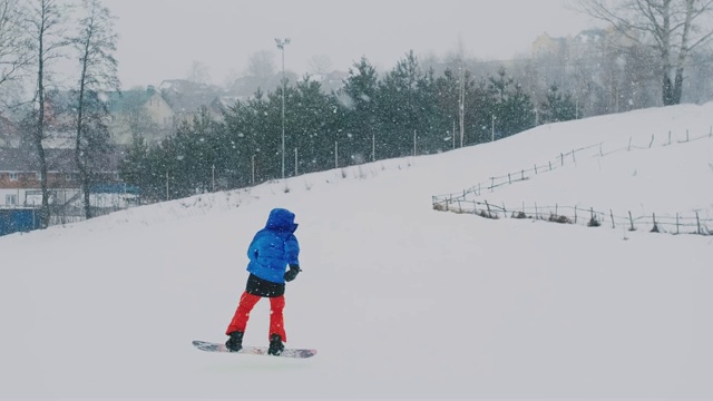 从滑雪坡上慢动作骑在滑雪板上的男子视频下载