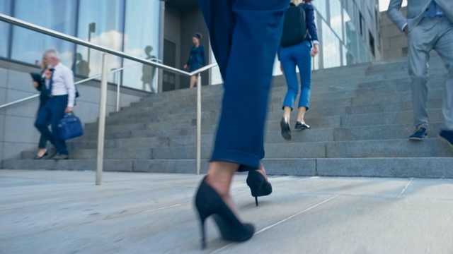 SLO MO TS一双女商人的腿，穿着高跟鞋和商务套装，正走在商业大厦外的楼梯上视频素材