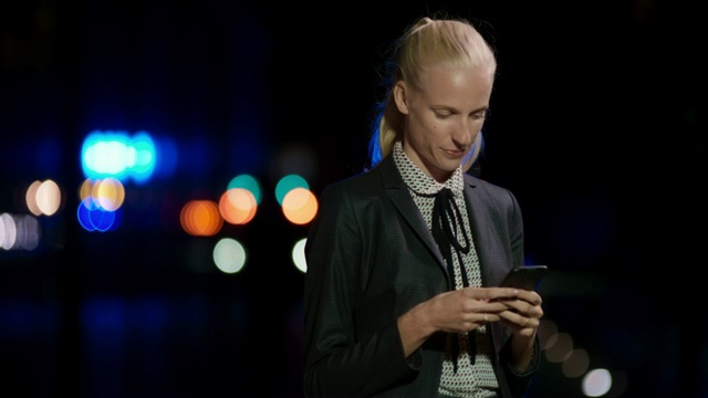 LD年轻的白人女企业家站在外面，微笑着用她的智能手机打字视频素材