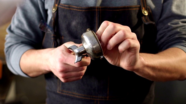 一个男性咖啡师的特写，用餐巾擦碎咖啡的滤嘴。视频素材
