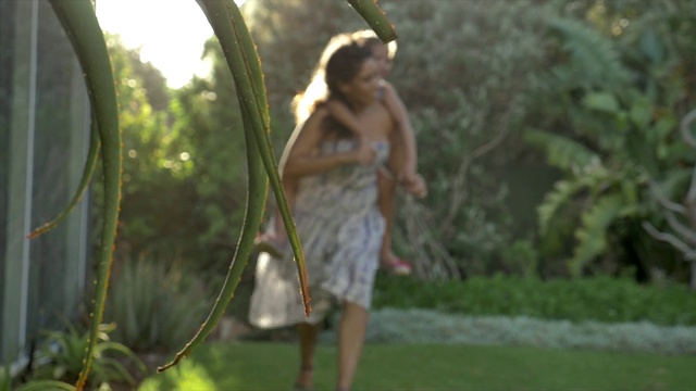 母亲在院子里背着女儿视频素材