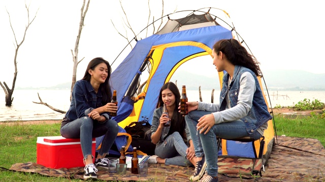 三个女人花周末时间露营和一起在日落的水边喝酒视频素材