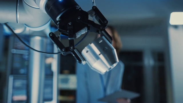 一个未来机器人手臂移动金属细节的特写。工程师团队观察这个技术先进的过程。他们在一个拥有现代化设备的高科技研究实验室里。视频下载