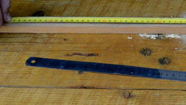 木匠用卷尺量一根木棒。视频下载