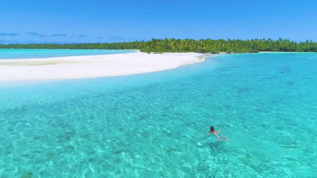 一位正在度假的年轻女子正游向热带白色沙滩视频下载