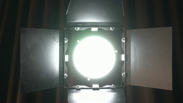 剧场演播室的聚光灯在棕色窗帘上。制作胶片的照明开关视频素材