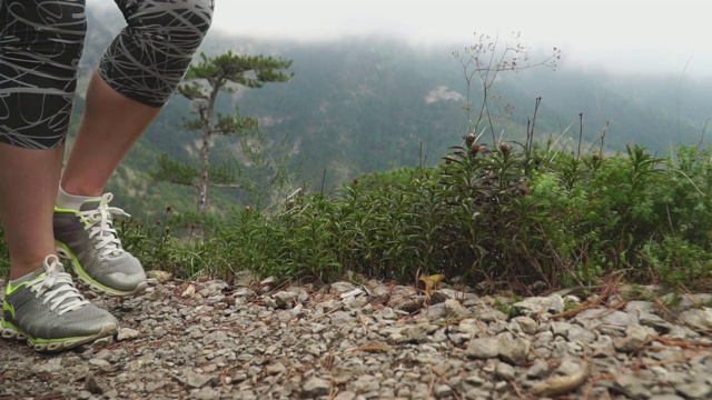 在夏天的一天，旅行者在山崖顶上行走的脚视频素材
