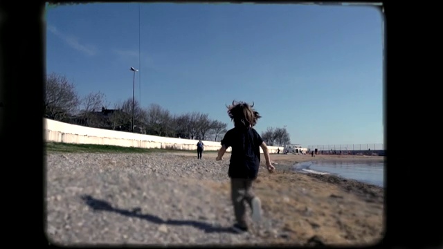 小男孩在沙滩上玩。8毫米镜头。视频下载