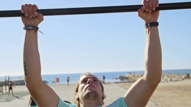 强壮的运动员在海滩上练习引体向上视频素材