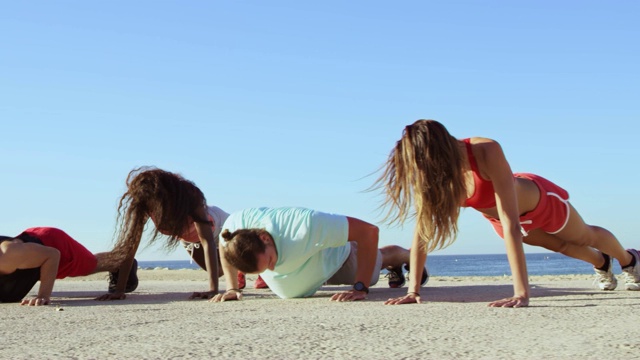 多莉拍摄了运动员在海滩上做俯卧撑的镜头视频下载