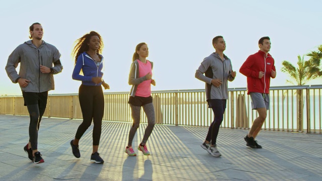 运动员在日落时在散步道上慢跑视频素材