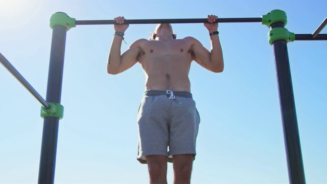 肌肉发达的运动员在体操杆上锻炼视频素材