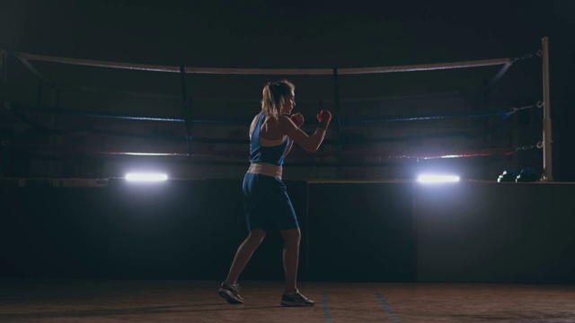 女拳击手在暗室训练，背光慢动作。替身拍摄视频素材